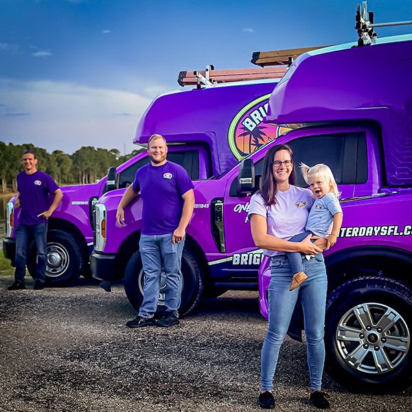 Brighter Day Electric Employees Standing Beside Their Vehicles in Port St. Lucie, FL