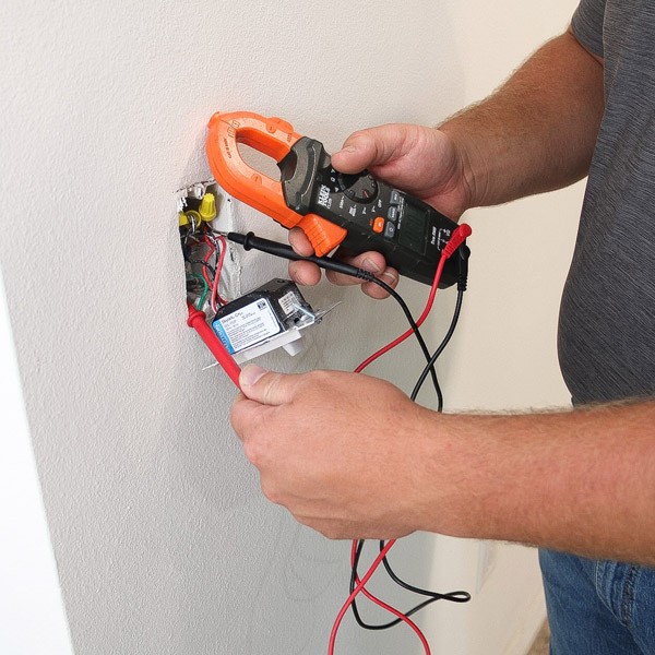 An electrician using a multimeter for electrical troubleshooting in Port St. Lucie, FL